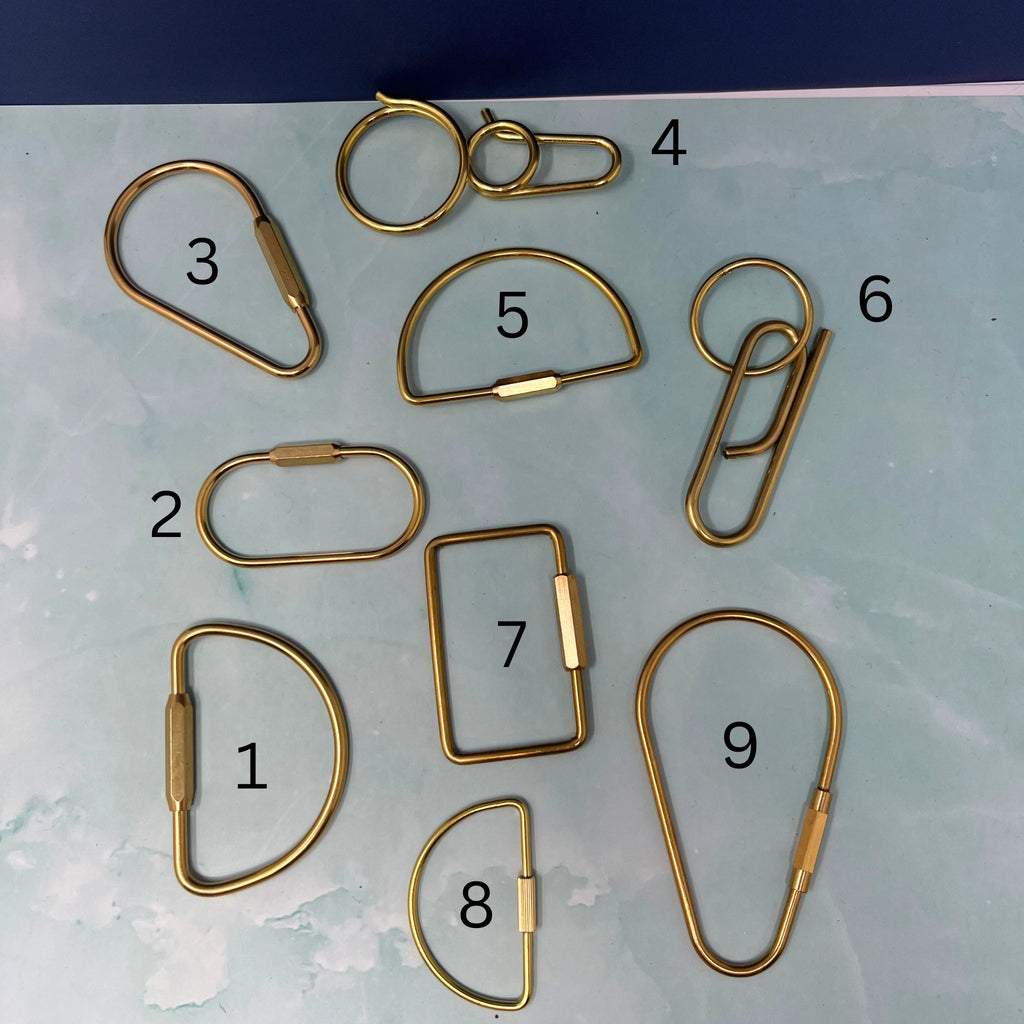Gold metal hooks of various shapes and sizes on a light blue background