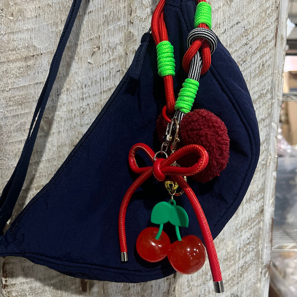 Cherry keychain with glossy cherries, red bow, green leaves, plush heart, and sporty nylon wristlet