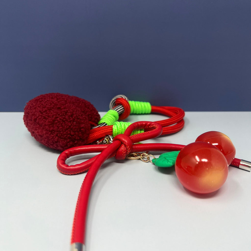 Cherry keychain with glossy cherries, red bow, green leaves, plush heart, and sporty nylon wristlet