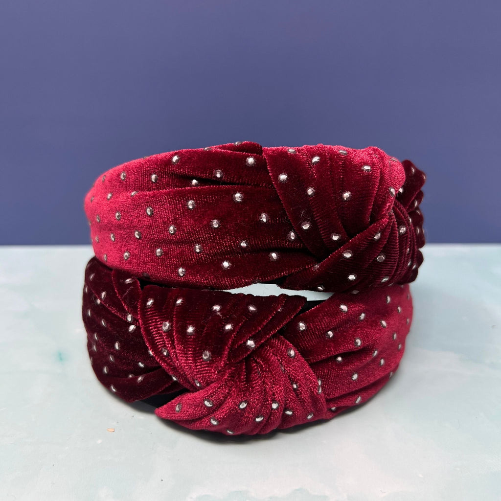 Two burgundy velvet headbands with rhinestone studs and knotted design stacked against a light background.