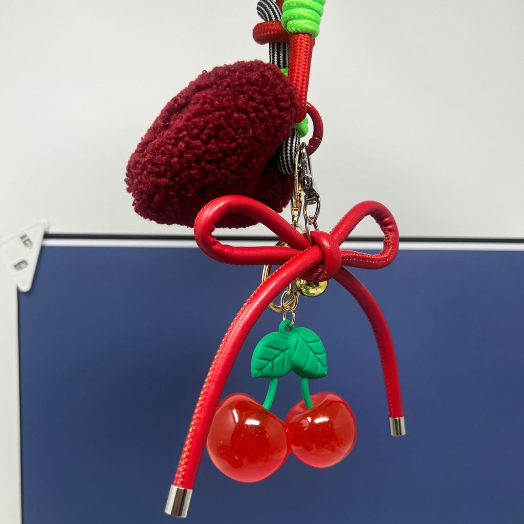 Cherry keychain with glossy cherries, red bow, green leaves, plush heart, and sporty nylon wristlet