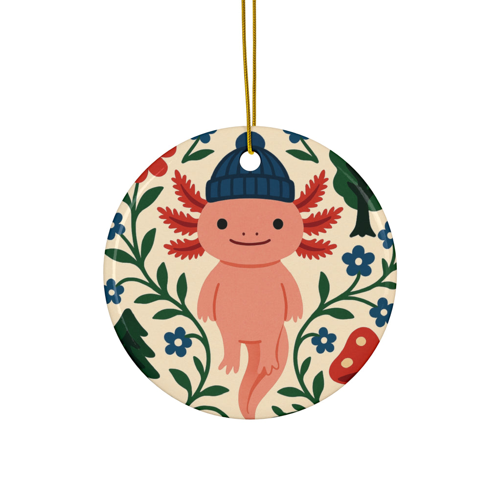 Circular ornament with a pink axolotl wearing a blue hat surrounded by flowers and leaves on a beige background.