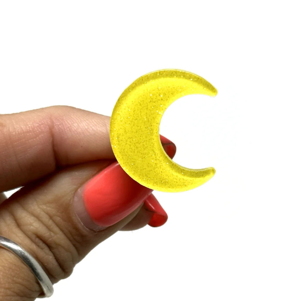 Set of two glittery crescent moon hair clips with secure alligator clip backing, each measuring 0.875" wide by 1" high.