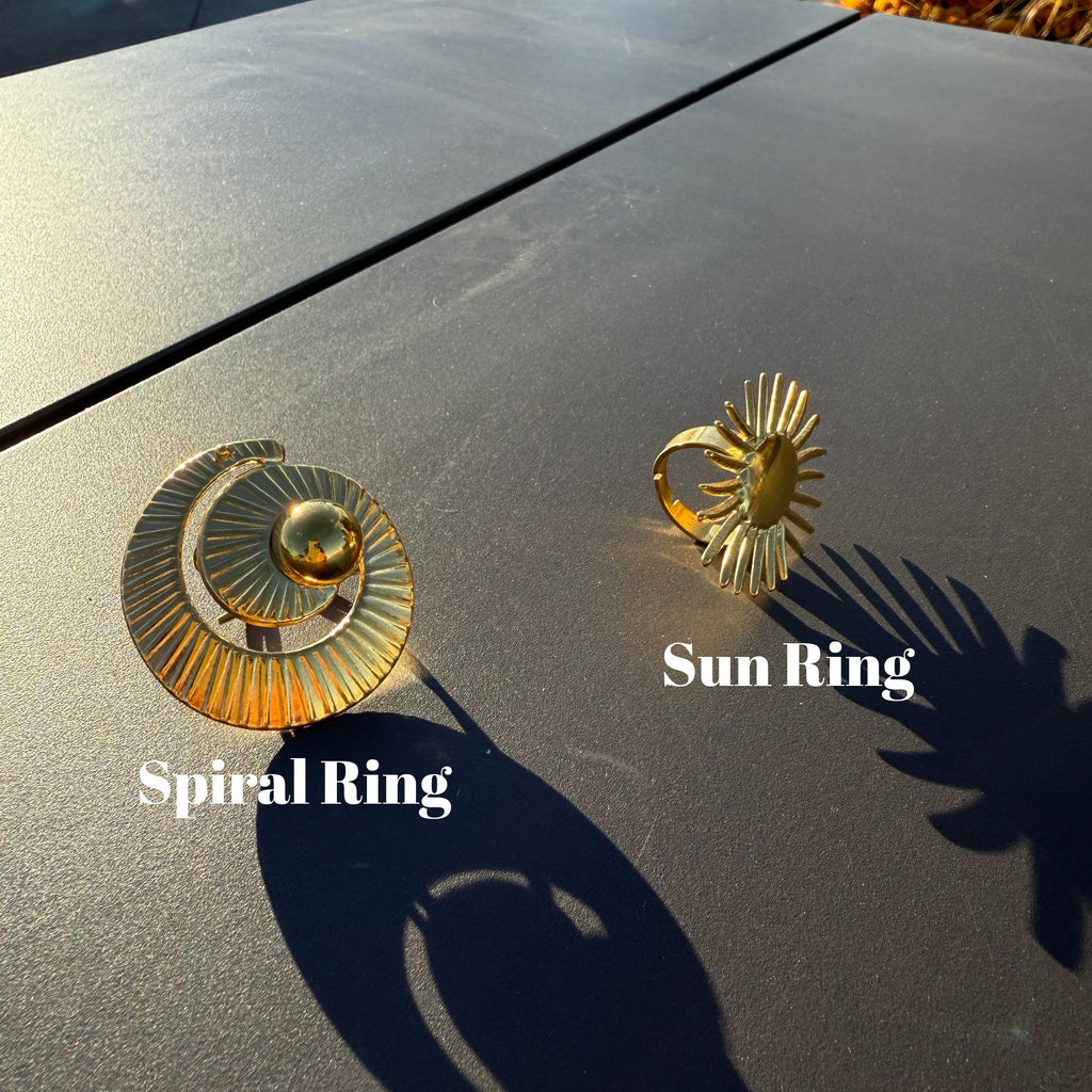 Gold spiral statement ring casting long shadow in sunlight