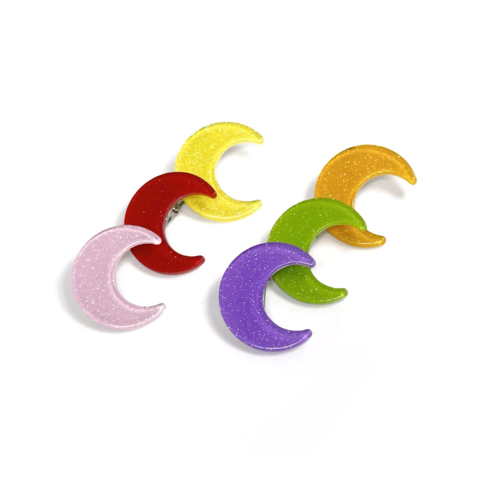 Set of two glittery crescent moon hair clips with secure alligator clip backing, each measuring 0.875" wide by 1" high.