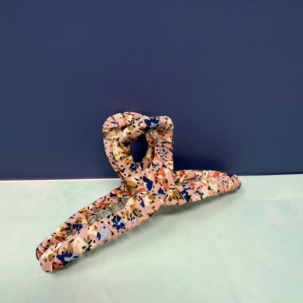 Floral-patterned hanger on a light green surface with a dark blue background