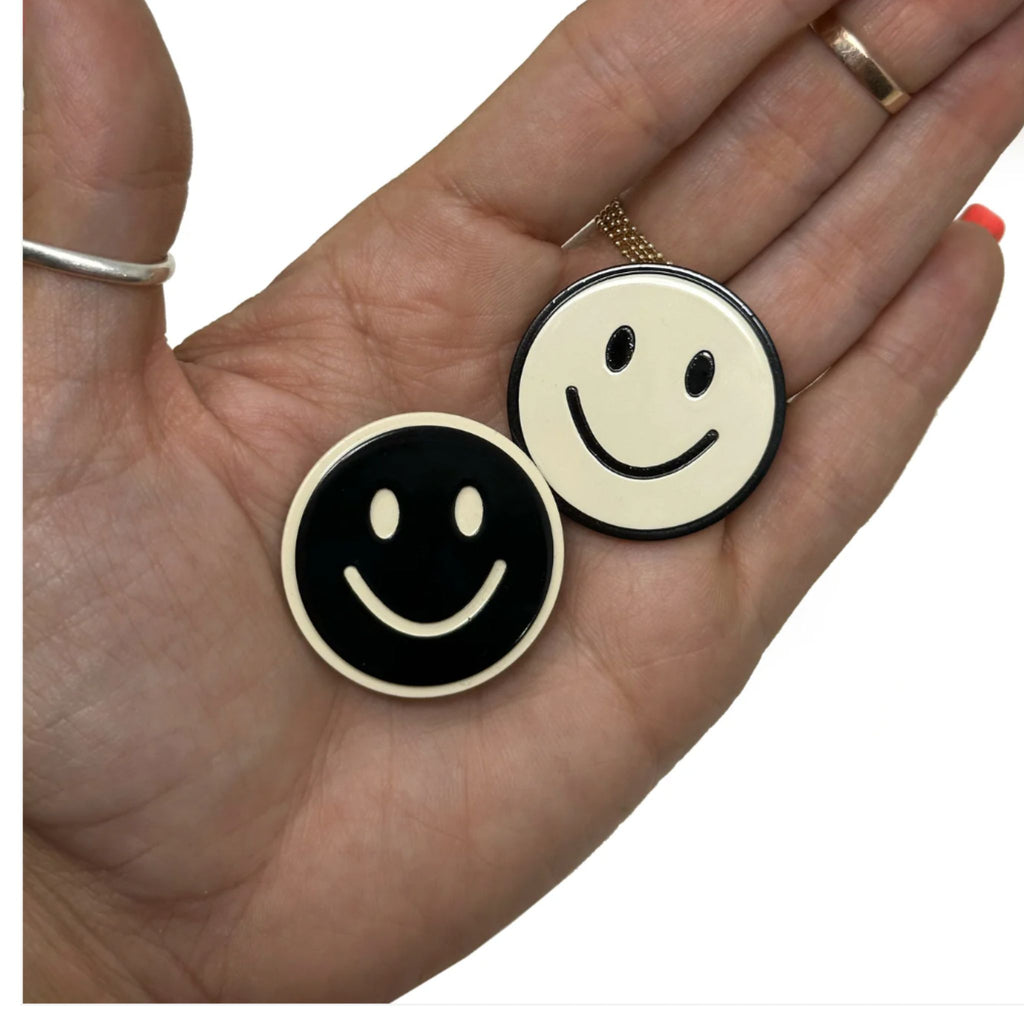 Set of two black and white smiley face hair clips with alligator clip backing, each measuring approximately 1.25" in diameter.