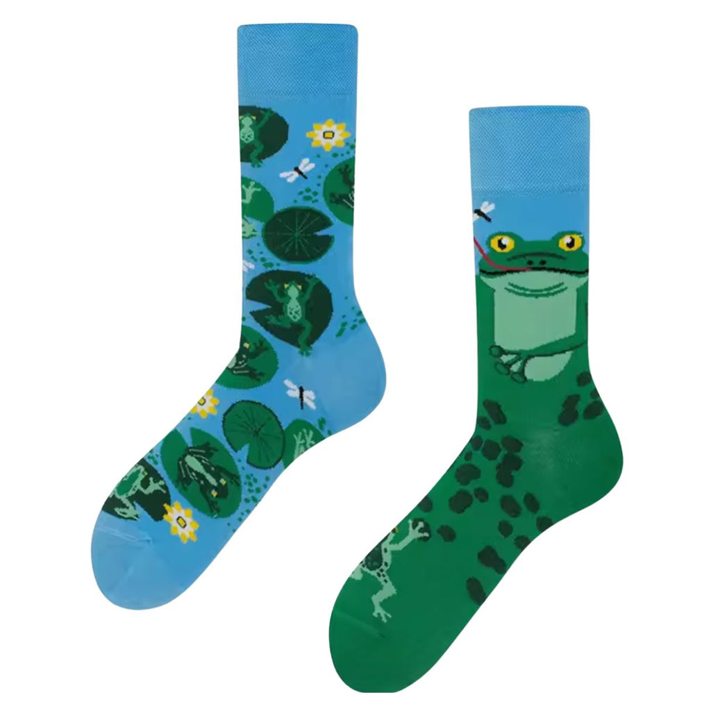 Pair of colorful mismatched socks—one light blue with frogs sitting on lily pads and dragonflies, the other green with a cartoon frog face catching a dragonfly with its tongue.