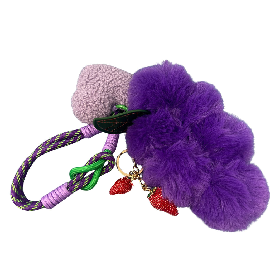 Plush keychain featuring a purple grape cluster, lavender heart, and two red strawberry charms with a colorful rope loop.