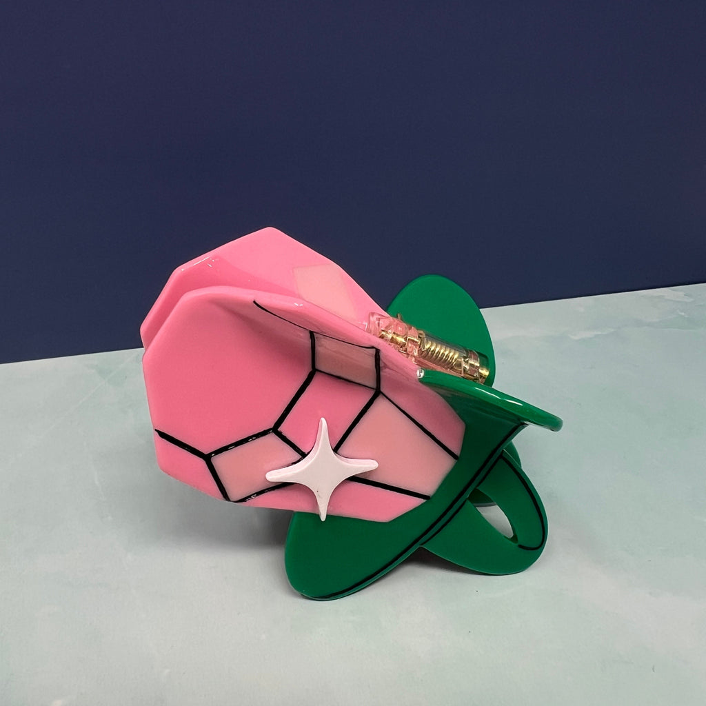 Candy Ring Pop-inspired hair claw with a faceted pink gem, green base, and white sparkle detail on a flat background