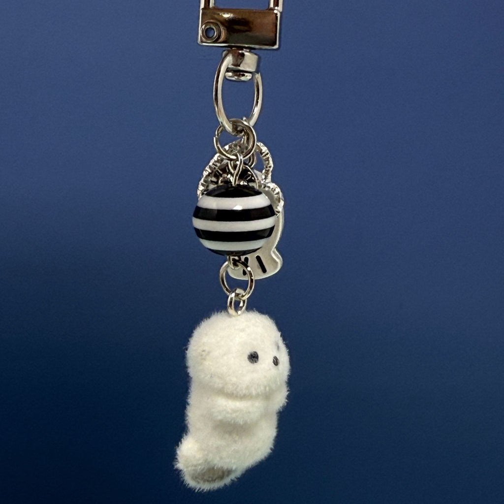 Flocked otter keychain with soft fuzzy white body, striped bead, fish charm, and silver keyring clasp