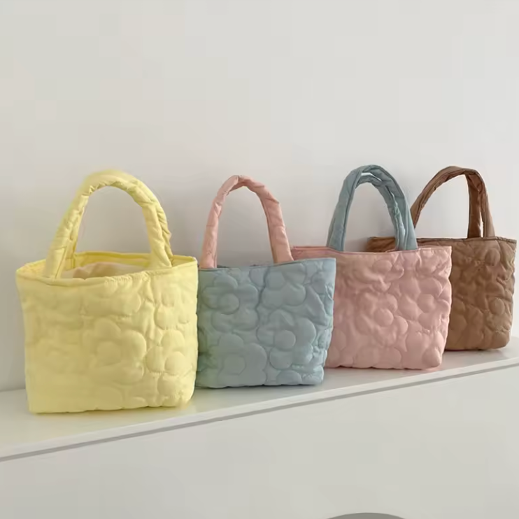 "Quilted daisy tote bag in soft nylon/poly blend, featuring a charming floral pattern."