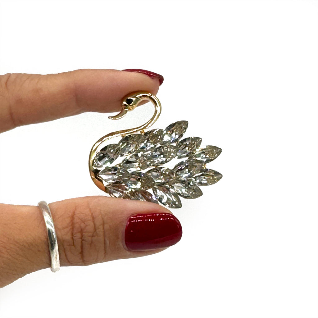  White sneaker with gold swan shoe charm featuring crystal rhinestone wings.